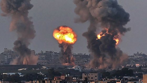 Smoke and a ball of fire rise above buildings in Khan Yunis in the southern Gaza Strip, during an Israeli air strike, on May 12, 2021. - Israeli air raids in the Gaza Strip have hit the homes of high-ranking members of the Hamas militant group, the military said Wednesday, with the territory's police headquarters also targeted. (Photo by SAID KHATIB / AFP)