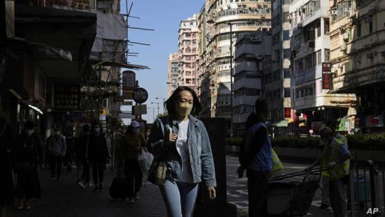 A woman wearing face a mask, walks down a street in Hong Kong, Monday, Nov. 29, 2021. The new omicron variant was found in Hong Kong, Belgium and Tel Aviv. The European Union, the United States and Britain imposed curbs on travel from Africa. Israel banned entry by foreigners. (AP Photo/Kin Cheung)