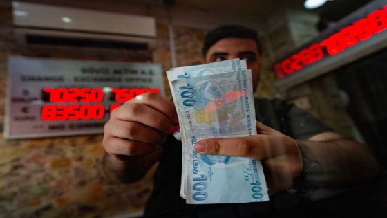 A currency exchange office worker counts Turkish Lira banknotes in front of the electronic panel displaying currency exchange rates at an exchange office in Istanbul, on August 6, 2020 as Turkey's lira set a new record low against the US dollar. - The lira on August 6 was trading at 7.28 against the greenback around 1030 GMT, suffering a loss of more than 3 percent since the start of the day -- the lowest since May when it reached a then-record low of 7.24. The currency also recorded its lowest level against the euro, trading near 8.60 against the European currency at 1030 GMT. (Photo by Yasin AKGUL / AFP)