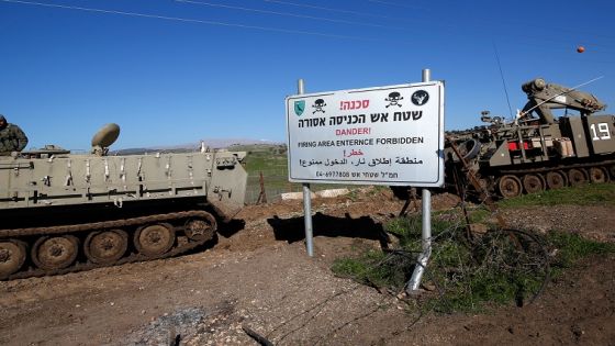 Israeli military vehicles are pictured near a warning sign during a military drill in the Israeli-annexed Golan Heights, on December 30, 2020. - Israeli air strikes in Syria targeting the pro-Damascus Lebanese Hezbollah group and Syrian air defence forces, killed one Syrian soldier and wounded five others, a war monitor said today. (Photo by JALAA MAREY / AFP)