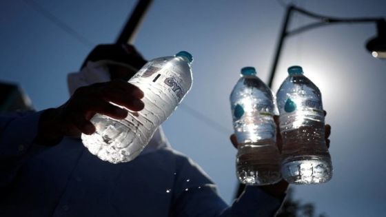 A man sells bottled water during a red traffic light as high temperatures continue, in Monterrey, Mexico, June 28, 2023. REUTERS/Daniel Becerril