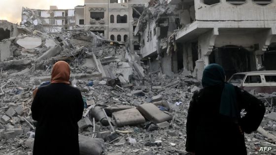 Two Palestinian women look at the massive destruction following Israeli airstrikes on Gaza City's al-Rimal district, on October 10, 2023. Israel kept up its deadly bombardment of Hamas-controlled Gaza on October 10 after the Palestinian militant group threatened to execute some of the around 150 hostages it abducted in a weekend assault if air strikes continue without warning. (Photo by Mahmud HAMS / AFP)