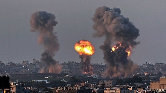 Smoke and a ball of fire rise above buildings in Khan Yunis in the southern Gaza Strip, during an Israeli air strike, on May 12, 2021. - Israeli air raids in the Gaza Strip have hit the homes of high-ranking members of the Hamas militant group, the military said Wednesday, with the territory's police headquarters also targeted. (Photo by SAID KHATIB / AFP)