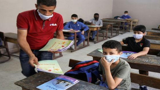 Students wearing protective face masks receive their new books at one of the public schools on the first day of the new school year, amid fears of rising number of the coronavirus disease (COVID-19) cases in Amman, Jordan September 1, 2020. REUTERS/Muhammad Hamed