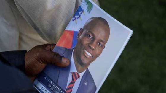 A person holds a photo of late Haitian President Jovenel Moise, who was shot dead earlier this month, during his funeral at his family home in Cap-Haitien, Haiti, July 23, 2021. REUTERS/Ricardo Arduengo