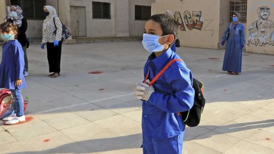 Students, wearing protective masks, wait in line on the first day of school in the Jordanian capital Amman amid the ongoing COVID-19 pandemic, on September 1, 2020. (Photo by Khalil MAZRAAWI / AFP)