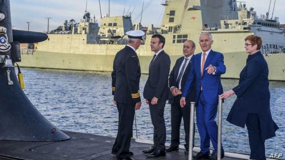 (FILES) A file photo taken on May 2, 2018 shows French President Emmanuel Macron (2/L) and Australian Prime Minister Malcolm Turnbull (2/R) standing on the deck of HMAS Waller, a Collins-class submarine operated by the Royal Australian Navy, at Garden Island in Sydney. - Australia is expected to scrapped a 66 billion USD deal for France to build submarines, replacing it with nuclear-powered subs using US and British technology. (Photo by BRENDAN ESPOSITO / POOL / AFP)