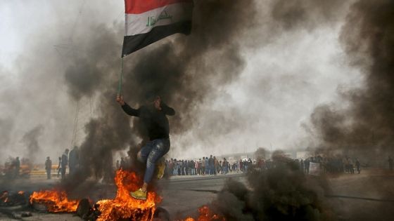 An Iraqi demonstrator jumps over a burning tire during anti-government protests in Basra, Iraq, December 20, 2020. REUTERS/Essam al-Sudani