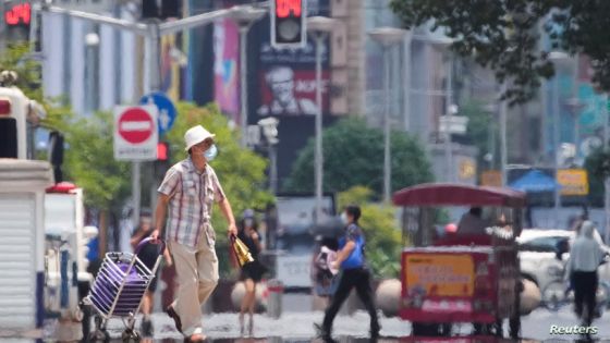 A man wearing a face mask pulls a cart on a street amid a heatwave warning, following the coronavirus disease (COVID-19) outbreak in Shanghai, China July 13, 2022. REUTERS/Aly Song