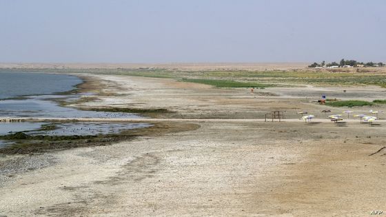 A picture shows the receding waterline of the Habbaniyah lake affected by severe drought in Iraq's Anbar province, on August 11, 2023. Water levels at Habbaniyah have receded by several dozen metres (feet) after four consecutive years of drought which has ravaged parts of the country, keeping away the holidaymakers who would flock there during summer. (Photo by Murtadha RIDHA / AFP)