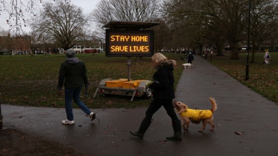 People walk past a newly placed sign on Eel Brook Common as EU countries impose a travel ban from the UK amid alarm about a rapidly spreading strain of coronavirus, in Fulham, London, Britain, December 21, 2020. REUTERS/Kevin Coombs