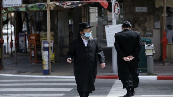 An ultra-Orthodox Jewish man wearing a protective mask crosses a street in the religious Israeli city of Bnei Brak, near Tel Aviv, on April 6, 2020, during the novel coronavirus pandemic crisis. - More than 7,000 cases of COVID-19, including 40 deaths, have been officially declared in Israel, half of which according to local media, are ultra-Orthodox Jews, prompting the Prime Minister on April 3, to give a green light for amry deployment in the city, considered the centre of the country's novel coronavirus outbreak. (Photo by MENAHEM KAHANA / AFP) (Photo by MENAHEM KAHANA/AFP via Getty Images)