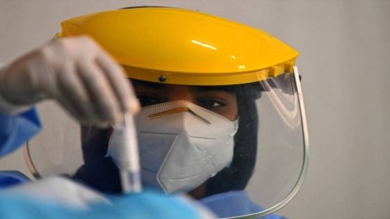 A health worker looks at a sample taken from a foreign worker to check for the novel coronavirus at a testing centre in the Al Quaz area of Dubai, in the United Arab Emirates, on April 18, 2020. (Photo by KARIM SAHIB / AFP);الإمارات تزود ولاية نيفادا الأمريكية بتقنية لتوسيع فحص «كورونا»