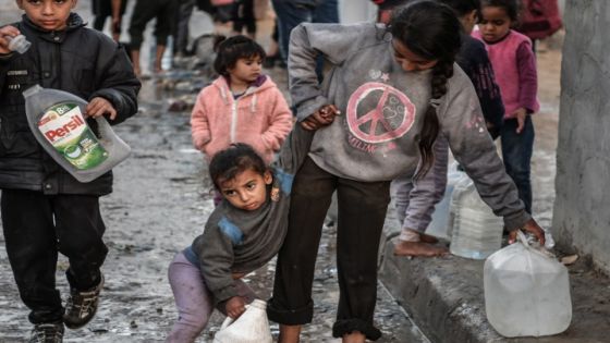 مع تفاقم الأزمة الإنسانية في غزة وسط الهجمات الإسرائيلية المكثفة، يكافح الأطفال الفلسطينيون مثل البالغين من أجل توفير الماء والغذاء لأسرهم. ويصطف الأطفال الذين يعيشون في الخيام بمدينة رفح جنوب القطاع هربا من الهجمات، للحصول على المياه التي توزعها الجمعيات الخيرية، حيث يقومون بتعبئة أواني المياه ونقلها إلى خيامهم باستخدام العربات اليدوية أو حملها بأيديهم رغم وزنها الزائد. ( Abed Zagout - وكالة الأناضول )