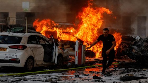 A man runs on a road as fire burns after rockets were launched from the Gaza Strip, in Ashkelon, Israel October 7, 2023. REUTERS/Amir Cohen