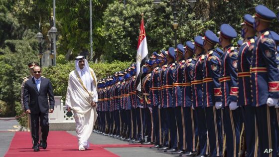 In this photo made available by Qatar News Agency, QNA, Qatari Emir Tamim bin Hamad Al Thani, and Egyptian President Abdel-Fattah el-Sissi, review an honor guard at the presidential palace in Cairo, Egypt, Saturday, June 25, 2022. Qatar's emir arrived in Cairo to hold talks with Egypt's president in his first visit since the two countries agreed to reset relations after more than seven years of diplomatic animosity. (QNA via AP)