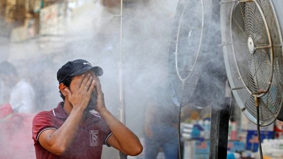 An Iraqi man cools down in front of misting fans amid a heatwave in central Baghdad, on July 20, 2022. (Photo by AHMAD AL-RUBAYE / AFP)