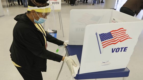 Board of elections worker ValerieTyree cleans an election booth after a person voted at the Cuyahoga County Board of Elections, Tuesday, April 28, 2020, in Cleveland. The first major test of an almost completely vote-by-mail election during a pandemic is unfolding Tuesday in Ohio, offering lessons to other states about how to conduct one of the most basic acts of democracy amid a health crisis. (AP Photo/Tony Dejak)