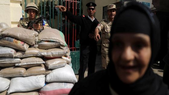 Members of security forces stand guard as a woman leaves a polling station during the second day of the presidential election in Cairo, Egypt, March 27, 2018. REUTERS/Ammar Awad