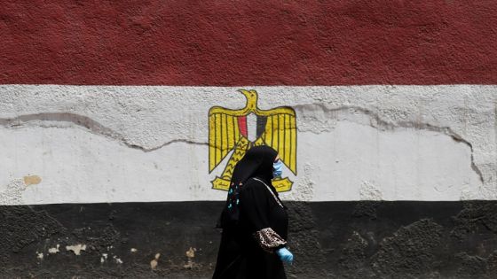 A woman wearing a protective face mask, amid concerns over the coronavirus disease (COVID-19), walks next to a wall painted with colors of the Egypt's flag during the holy month of Ramadan in Cairo, Egypt April 26, 2020. REUTERS/Amr Abdallah Dalsh