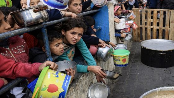 Palestinians children wait to collect food at a donation point in a refugee camp in Rafah in the southern Gaza Strip on December 23, 2023, amid continuing battles between Israel and the militant group Hamas. (Photo by Mahmud HAMS / AFP)