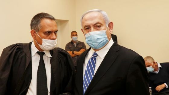 Israeli Prime Minister Benjamin Netanyahu (R), wearing a protective face maks, is pictured inside a courtroom at the district court of Jerusalem on May 24, 2020, during the first day of his corruption trial. - Fresh from forming a new government after more than 500 days of electoral deadlock, Netanyahu is expected to begin a new battle in the Jerusalem District Court -- to stay out of prison. The 70-year-old was scheduled to appear at a court hearing to formally confirm his identity to judges, after being indicted in January for bribery, fraud and breach of trust. (Photo by RONEN ZVULUN / POOL / AFP)