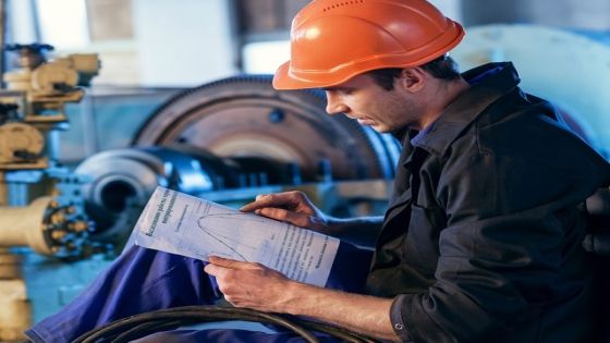 Worker on industry studying manual instructions for repair turbine.