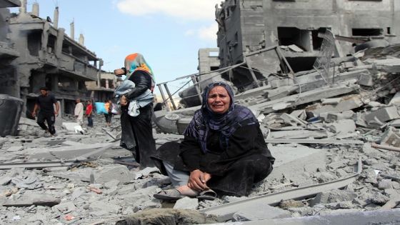 BEIT HANOUN, GAZA - JULY 26 : A Palestinian woman reacts amongst the debris of buildings as others try to find their belongings inside the debris of the buildings during a 12-hour humanitarian truce in Beit Hanoun, Gaza on July 26, 2014. (Photo by Ezz Zanoun/Anadolu Agency/Getty Images)