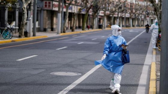 A worker in a protective suit keeps watch on a street, as the second stage of a two-stage lockdown to curb the spread of the coronavirus disease (COVID-19) begins in Shanghai, China April 1, 2022. REUTERS/Aly Song