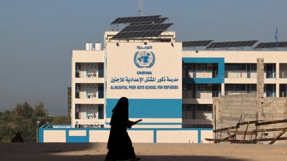 A Palestinian woman walks past the shuttered headquarters of the United Nations Relief and Works Agency for Refugees (UNRWA) in Gaza City during a general strike of employees in UNRWA institutions in the Palestinian strip, on November 29, 2021. (Photo by Mohammed ABED / AFP)