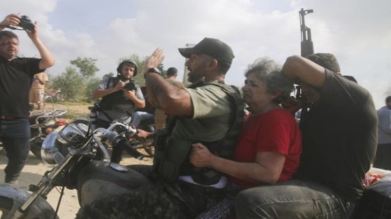 Palestinians transport a captured Israeli civilian, center, from Kibbutz Kfar Azza into the Gaza Strip on Saturday, Oct. 7, 2023. The militant Hamas rulers of the Gaza Strip carried out an unprecedented, multi-front attack on Israel at daybreak Saturday, firing thousands of rockets as dozens of Hamas fighters infiltrated the heavily fortified border in several locations by air, land, and sea and catching the country off-guard on a major holiday. (AP Photo/Hatem Ali)