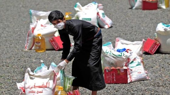 TOPSHOT - A Yemeni youth carries a portion of food aid, distributed by Yadon Tabney development foundation, in Yemen's capital Sanaa on May 17m 2020. (Photo by MOHAMMED HUWAIS / AFP)