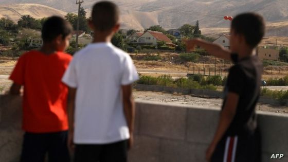 Children gaze at the Jewish settlement of Tomer, from the rooftop of a house in the Palestinian village of Fasayil, in the Jordan Valley on June 17, 2020. - Israel intends to annex West Bank settlements and the Jordan Valley, as proposed by US President Donald Trump, with initial steps slated to begin from July 1. (Photo by JAAFAR ASHTIYEH / AFP)