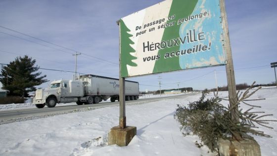 A welcoming sign in French stands on a road in the small Quebec town of Hérouxville 30 January 2007. The Canadian town is at the center of a controversy over its position on the reasonable accommodation of racial, ethnic and religious minorities. Rules passed recently by the town's council are: no stoning of women, and making sure women are allowed to drive cars. The sign reads: "Whether passing through or staying a while, Herouxville welcomes you!" AFP PHOTO/David BOILY (Photo by DAVID BOILY / AFP)