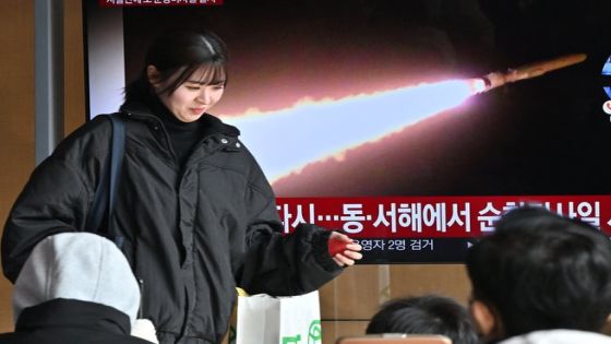 A woman walks past a television screen showing a news broadcast with file footage of a North Korean missile test, at a railway station in Seoul on February 2, 2024. North Korea fired multiple cruise missiles on February 2, Seoul's military said, continuing a fresh streak of weapons testing as Kim Jong Un's regime ramps up what it calls "war preparations". (Photo by Jung Yeon-je / AFP)
