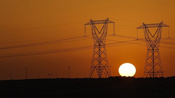 The sun sets behind high voltage transmission towers (electricity pylons) along a highway in El-Shorouk, a satellite city about 47 kilometres outside the city-centre of Cairo, on July 24, 2023. Egypt's prime minister on July 27 announced a number of measures, including planned power cuts, to cut down on energy consumption as the country and wider region faces a brutal heat wave. Civil servants will work from home one day a week in a bid to ease the load on local electricity networks, Mostafa Madbouli said in televised remarks, as temperatures in Cairo were expected to surpass 40 degrees Celsius (104 Fahrenheit) during the week. (Photo by Khaled DESOUKI / AFP)