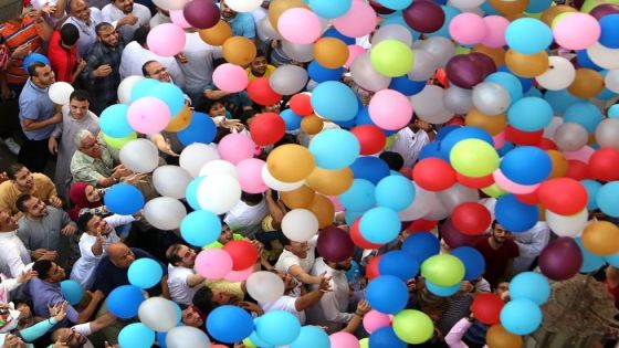 People attempt to catch balloons released after Eid al-Fitr prayers, marking the end of the Muslim holy fasting month of Ramadan at a public park, outside El-Seddik Mosque in Cairo, Egypt June 5, 2019. REUTERS/Mohamed Abd El Ghany