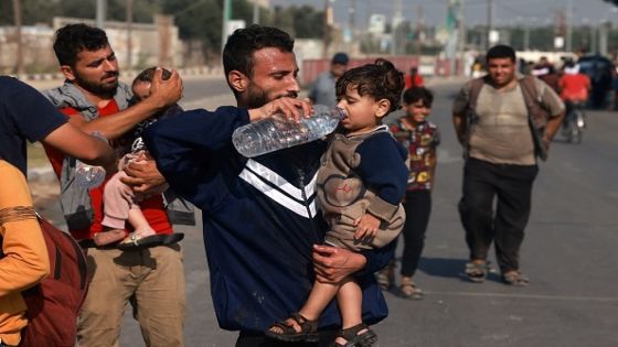 Men help toddlers to drink some water upon reaching the central Gaza Strip on foot via the Salah al-Din road on their way to the southern part of the Palestinian enclave on November 5, 2023. Leaflets dropped by the Israeli army on November 5, urged Gaza City residents to evacuate south between 10 am (0800 GMT) and 2 pm (1200 GMT), a day after a US official said at least 350,000 civilians remained in and around the city that is now an urban war zone. (Photo by MOHAMMED ABED / AFP) (Photo by MOHAMMED ABED/AFP via Getty Images)