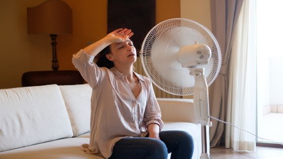 Woman feeling hot and trying to refresh in summertime heat