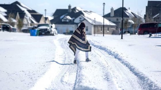 A man walks to his friend's home in a neighbourhood without electricity as snow covers the BlackHawk neighborhood in Pflugerville, Texas, U.S. February 15, 2021. Picture taken February 15, 2021. Bronte Wittpenn/Austin American-Statesman/USA Today Network via REUTERS. NO RESALES. NO ARCHIVES. MANDATORY CREDIT