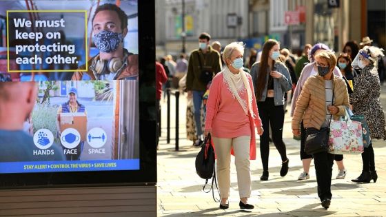 Shoppers, some wearing a face mask or covering, walk past an electronic billboard displaying a UK Government advert advising the public to take precautions to mitigate the spread of COVID-19, in Newcastle city centre, north-east England, on September 17, 2020. - The British government on Thursday announced new restrictions for northeast England, the latest region to see a surge in coronavirus cases as Prime Minister Boris Johnson warned of a "second hump" in nationwide transmission. Residents in the northeast, which includes the cities of Newcastle and Sunderland, will no longer be allowed to socialise outside their own homes or support bubble from Friday onwards. (Photo by Oli SCARFF / AFP)