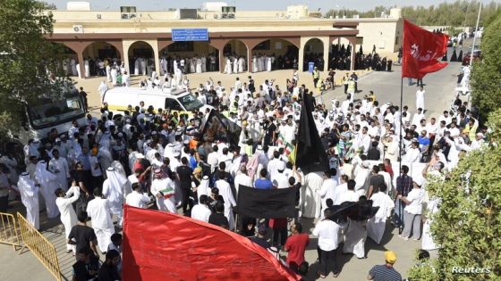 Mourners hold flags with names of Prophet Mohammad's family members as the bodies of victims of the Friday bombing are transferred to vehicles to be transported to Karbala, Iraq, at Al Jafariya cemetery in Suleibikhat, Kuwait June 27, 2015. Kuwait has arrested several people on suspicion of involvement in the bombing of a Shi'ite Muslim mosque on Friday that killed 27 people, a security source said on Saturday as the Gulf state marked a day of national mourning and prepared a mass funeral. Seven bodies were transported to Karbala to be buried there, after mourners said prayers over their bodies at the cemetery. REUTERS/Jassim Mohammed