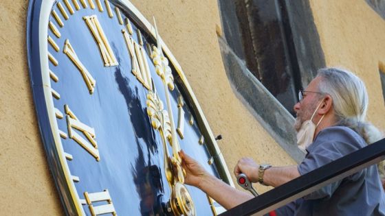 01 June 2021, Hessen, Frankfurt/Main: Restorer Reinhard Glasemann screws the large, gold-plated hands onto one of the two clocks in the Rententurm, which was part of Frankfurt's former city fortifications. The clocks are serviced and cleaned once a year. Photo: Frank Rumpenhorst/dpa (Photo by Frank Rumpenhorst/picture alliance via Getty Images)