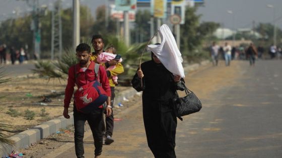 A Palestinian woman holds a white flag while evacuating with a group of civilians from the north of the Gaza Strip towards south, amid the ongoing conflict between Israel and Palestinian Islamist group Hamas, in the central Gaza Strip November 7, 2023. REUTERS/Ahmed Zakot TPX IMAGES OF THE DAY