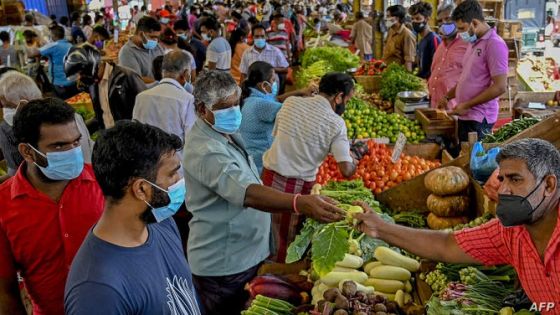 People buy vegetables at a market in Colombo on June 21, 2021 after the government lifted the lockdown which was earlier imposed to curb the spread of Covid-19 coronavirus. (Photo by ISHARA S. KODIKARA / AFP)