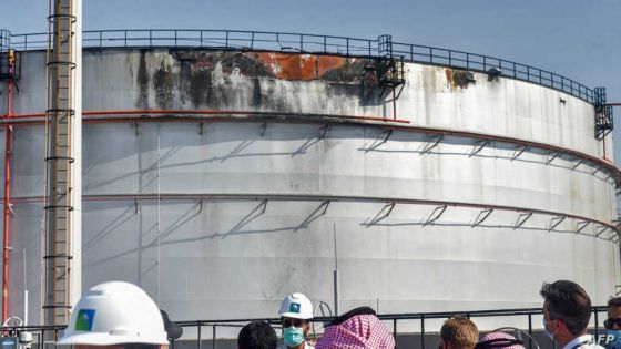 Journalists look at a damaged silo a day after an attack at the Saudi Aramco oil facility in Saudi Arabia's Red Sea city of Jeddah, on November 24, 2020. - Yemen's Huthi rebels launched a missile attack on the facility on November 23, triggering an explosion and a fire in a fuel tank, officials said. The strike occurred the day after the kingdom hosted a virtual summit of G20 nations, and more than a year after the targeting of major Aramco sites that caused turmoil on global oil markets. (Photo by FAYEZ NURELDINE / AFP)