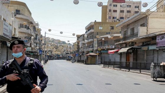 A policeman stands on guard while enforcing a curfew due to the COVID-19 coronavirus pandemic along a street in Jordan's capital Amman on August 28, 2020. - Jordan on August 28 started imposing a full curfew in Amman and Zarqa, 23 kilometres north-east of the capital, after a hike in the number of coronavirus cases. The country also cancelled the 2020 edition of the annual Jerash Festival of Culture and Arts. (Photo by Khalil MAZRAAWI / AFP)