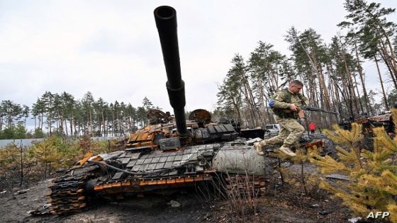 A Ukrainian serviceman jumps off a destroyed Russian army tank, not far from the Ukrainian capital of Kyiv on April 3, 2022. - Europe's worst conflict in decades, sparked by Russia's invasion on February 24, has already left some 20,000 people dead, according to Ukrainian estimates. (Photo by Sergei SUPINSKY / AFP)