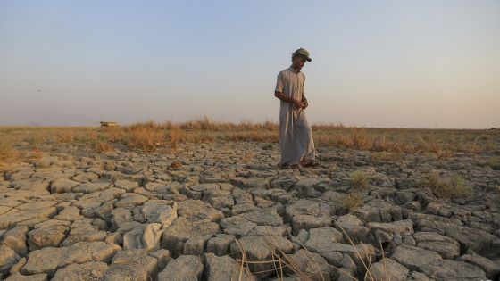 A fisherman walks across a dry patch of land in the marshes of southern Iraq which has suffered dire consequences from back to back drought and rising salinity levels, in Dhi Qar province, Iraq, Friday Sept. 2, 2022. (AP Photo/Anmar Khalil)