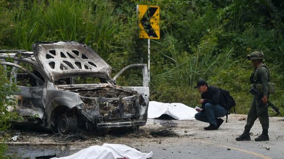 Police agents inspect a burned police patrol truck surrounded by the bodies of the two policemen that died this Saturday after an attack with explosive charges, in the municipality of Caldono, department of Cauca, Colombia, on March 3, 2018. According to authorities former FARC guerrilla dissidents operate in that area. / AFP PHOTO / Luis ROBAYO (Photo credit should read LUIS ROBAYO/AFP via Getty Images)